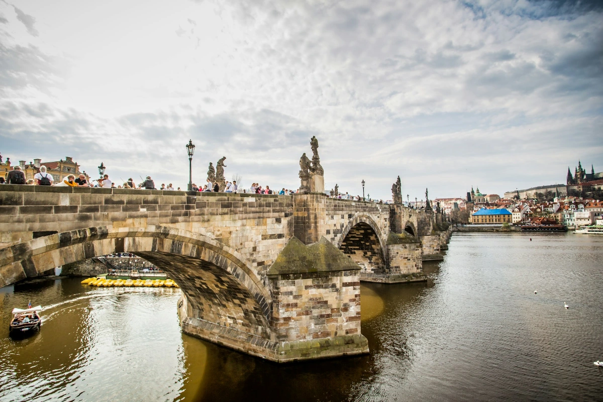 Walk across Charles Bridge at sunrise in Prague